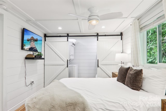 bedroom with hardwood / wood-style floors, wooden walls, and ceiling fan