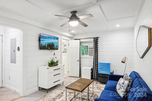 living room featuring light hardwood / wood-style floors, wood walls, electric panel, and ceiling fan