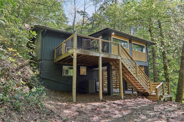 rear view of house with a deck and cooling unit