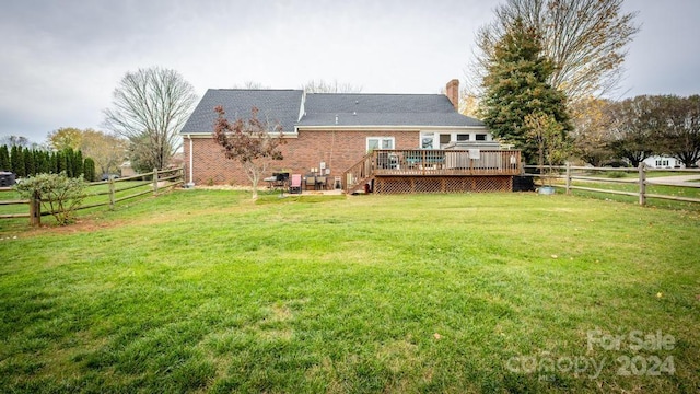 rear view of property featuring a yard and a deck