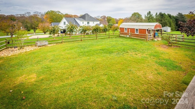 view of yard with an outbuilding and a rural view