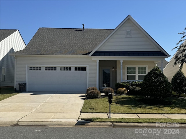 view of front of property featuring a front yard and a garage