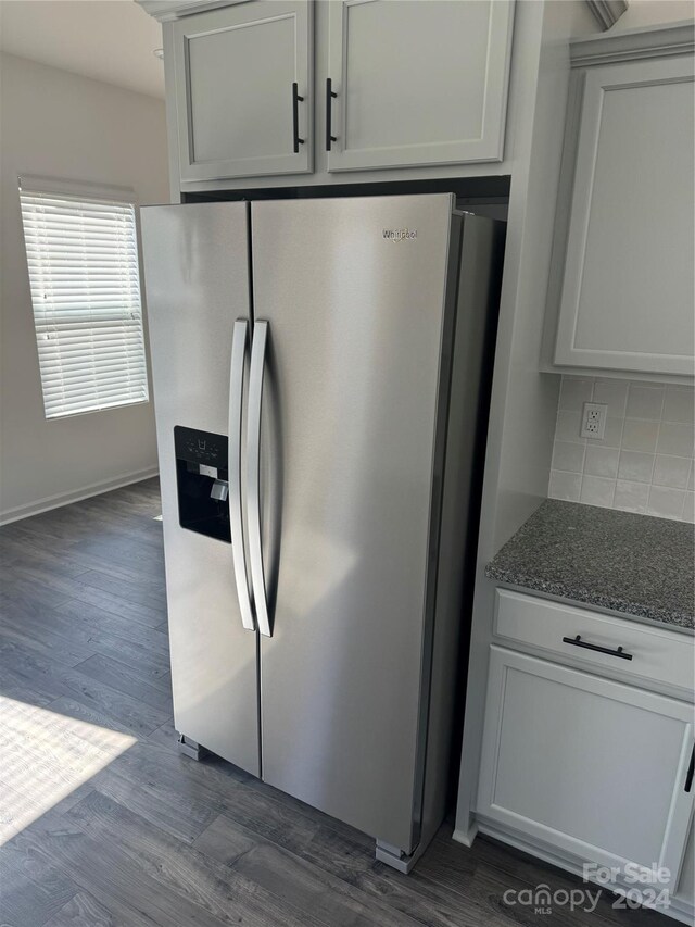 kitchen featuring decorative backsplash, dark hardwood / wood-style floors, white cabinets, and stainless steel fridge with ice dispenser