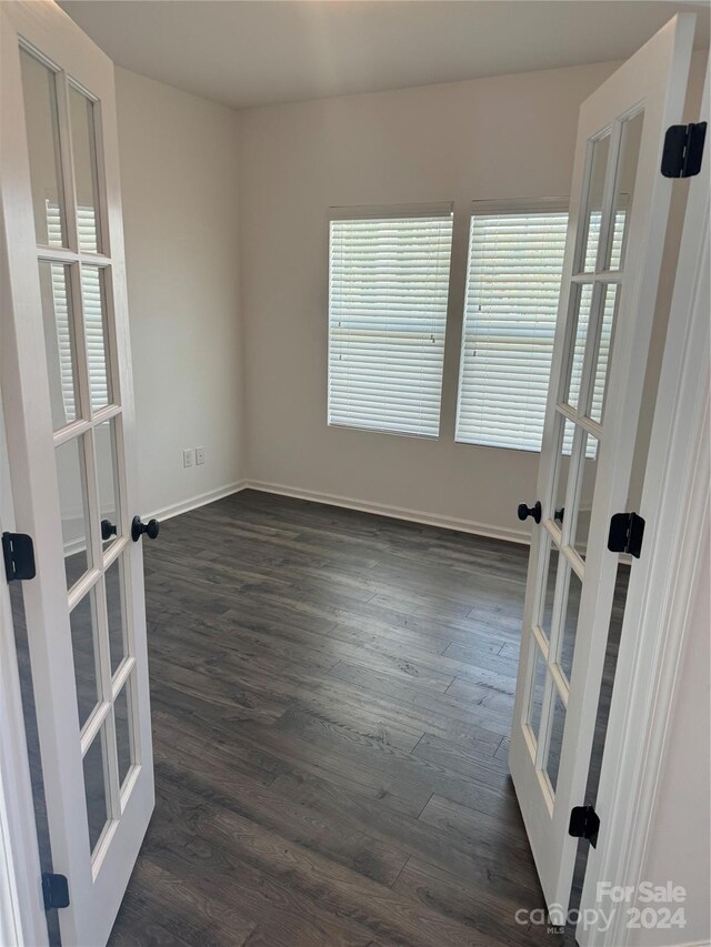 spare room with french doors and dark hardwood / wood-style floors