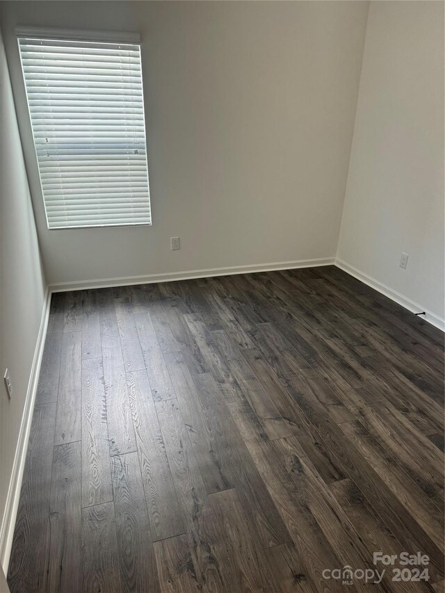 empty room with dark wood-type flooring