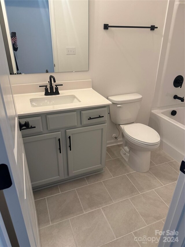 full bathroom featuring toilet, vanity, tile patterned floors, and tub / shower combination