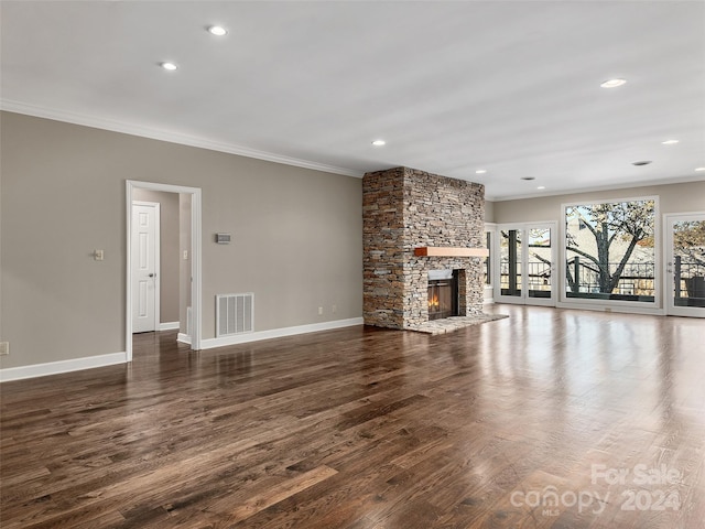 unfurnished living room featuring crown molding, a fireplace, and dark hardwood / wood-style flooring