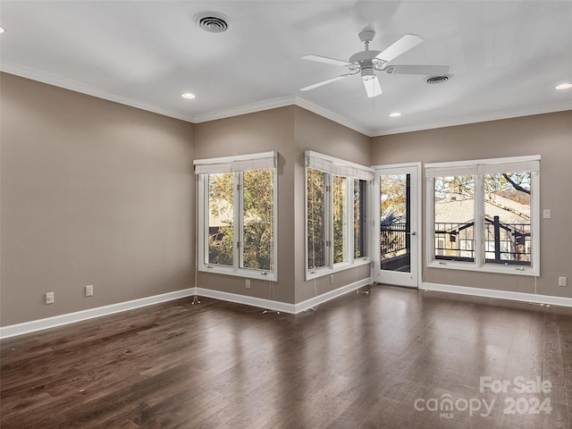 spare room featuring ceiling fan, crown molding, a wealth of natural light, and dark hardwood / wood-style flooring