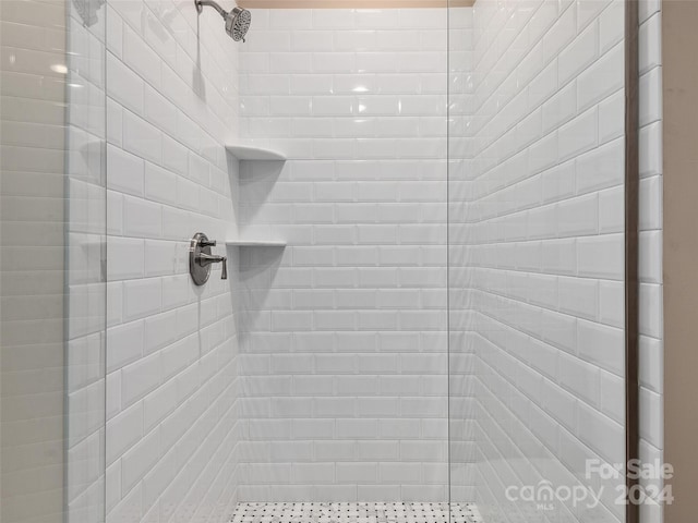 interior details featuring tiled shower