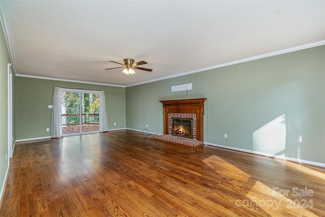 unfurnished living room featuring hardwood / wood-style floors, ceiling fan, a textured ceiling, a fireplace, and crown molding