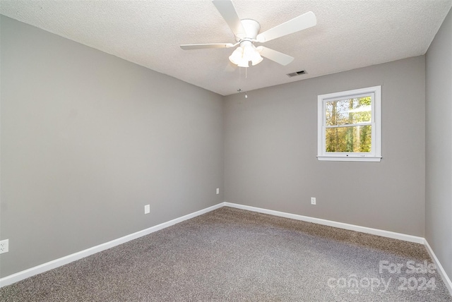 carpeted spare room with a textured ceiling and ceiling fan