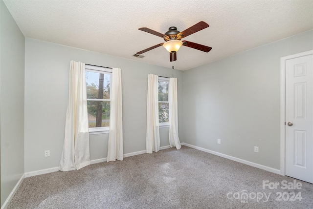 unfurnished room featuring carpet floors, a textured ceiling, and ceiling fan