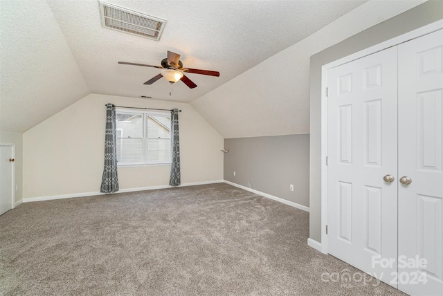 bonus room featuring light carpet, lofted ceiling, a textured ceiling, and ceiling fan