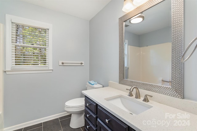 bathroom with toilet, vanity, and tile patterned floors