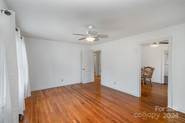 empty room with hardwood / wood-style flooring and ceiling fan