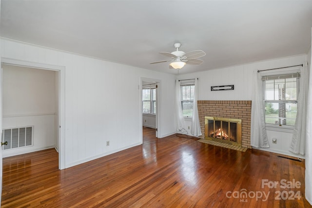 unfurnished living room with hardwood / wood-style floors, ceiling fan, and a fireplace