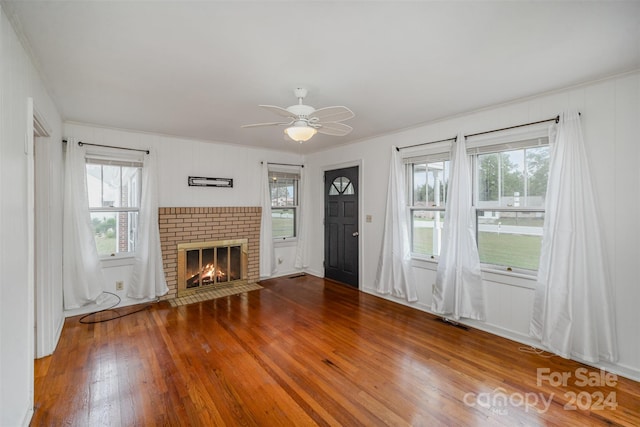 unfurnished living room with ceiling fan, wood-type flooring, a healthy amount of sunlight, and a fireplace