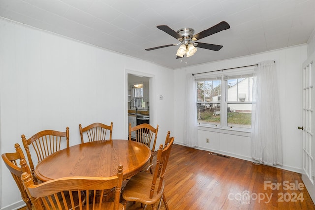 dining area with dark wood-type flooring, sink, and ceiling fan