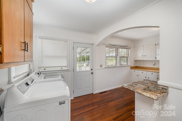 laundry area featuring cabinets, ornamental molding, dark hardwood / wood-style floors, and independent washer and dryer