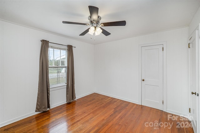 spare room featuring dark wood-type flooring and ceiling fan