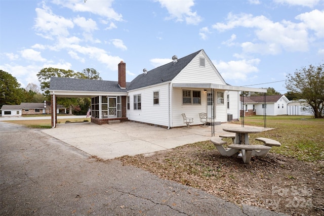 view of front of property featuring a front yard and a sunroom