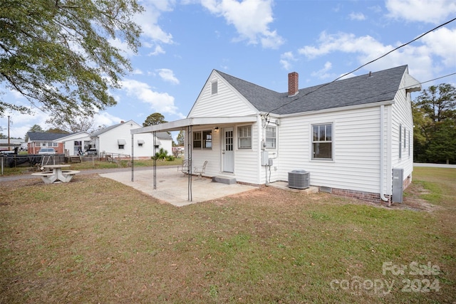 back of house featuring central AC unit, a yard, and a patio area