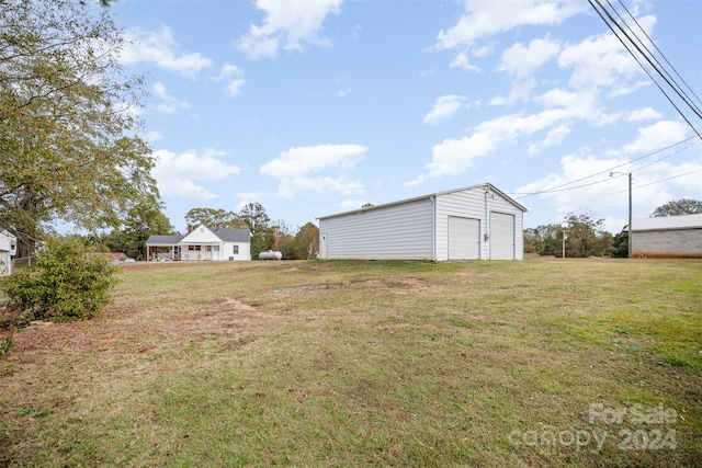 view of yard with a garage and an outbuilding