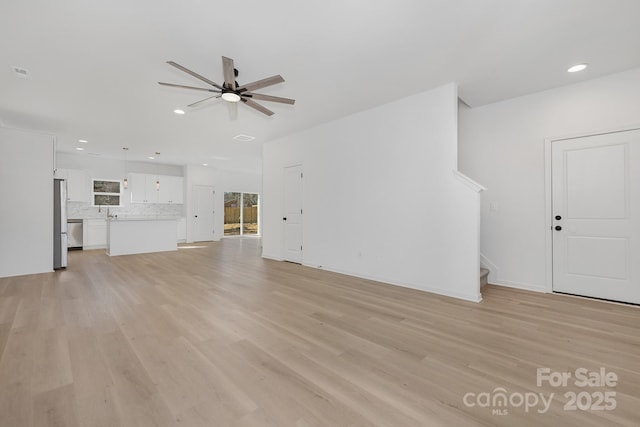 unfurnished living room featuring ceiling fan and light hardwood / wood-style floors