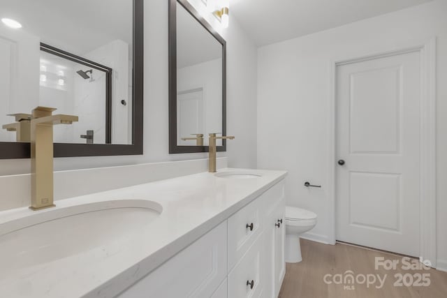 bathroom with vanity, toilet, hardwood / wood-style flooring, and a shower with door