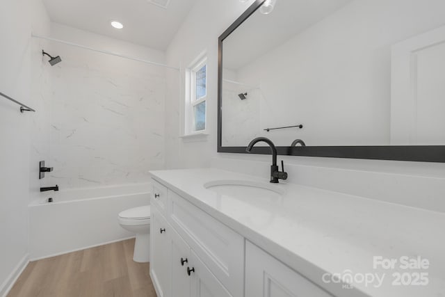 full bathroom featuring hardwood / wood-style flooring, toilet, vanity, and tiled shower / bath combo