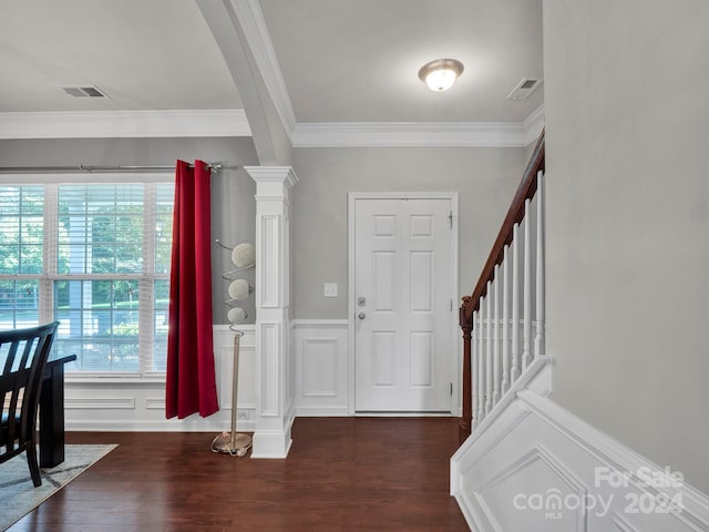 entrance foyer with ornamental molding, decorative columns, and dark hardwood / wood-style flooring