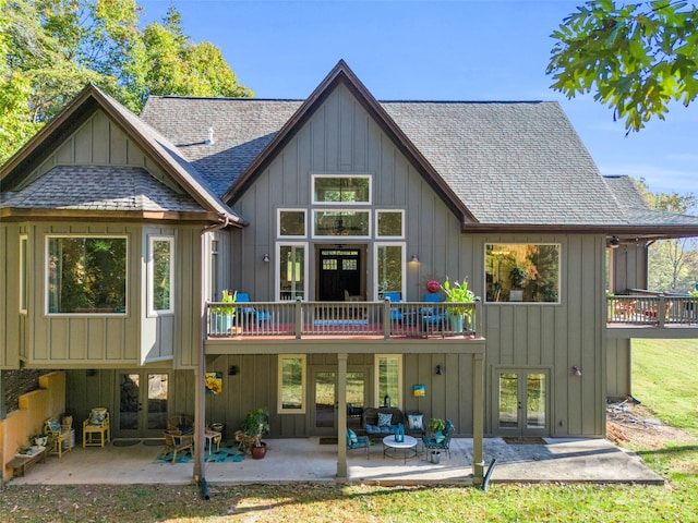 rear view of house with a patio, a wooden deck, and a yard