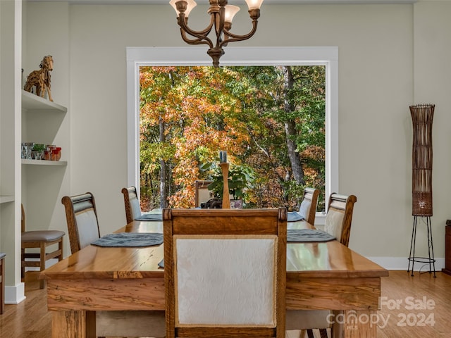 dining space featuring hardwood / wood-style flooring and a chandelier