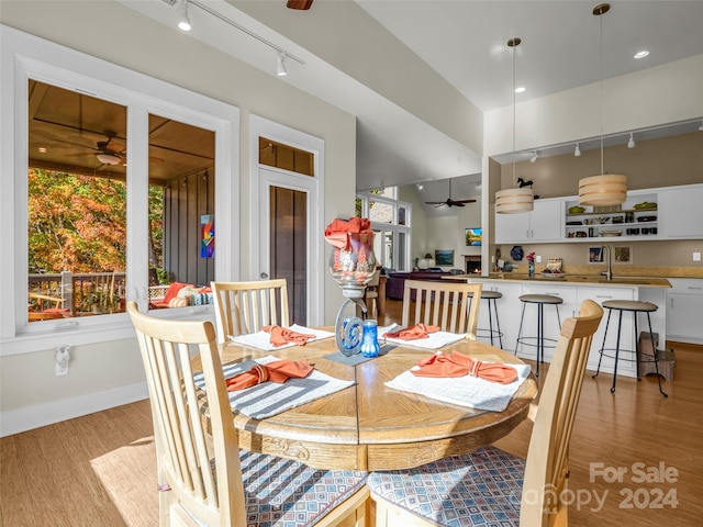 dining room featuring rail lighting, ceiling fan, and light wood-type flooring