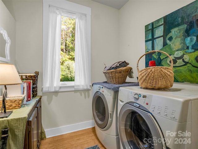 clothes washing area featuring light hardwood / wood-style flooring and washing machine and clothes dryer