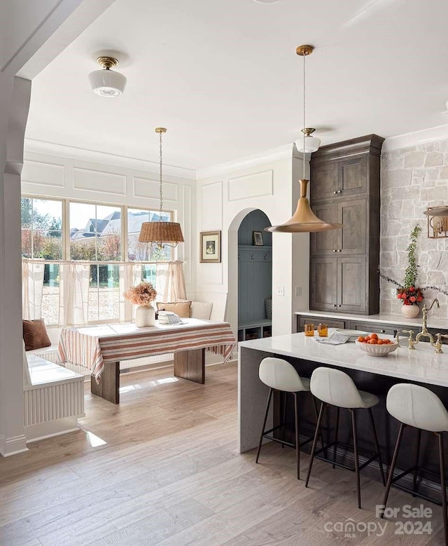 kitchen featuring light hardwood / wood-style floors, hanging light fixtures, and a kitchen breakfast bar