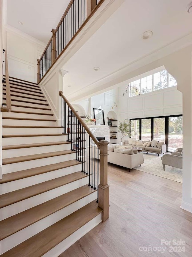 stairway featuring wood-type flooring and ornamental molding