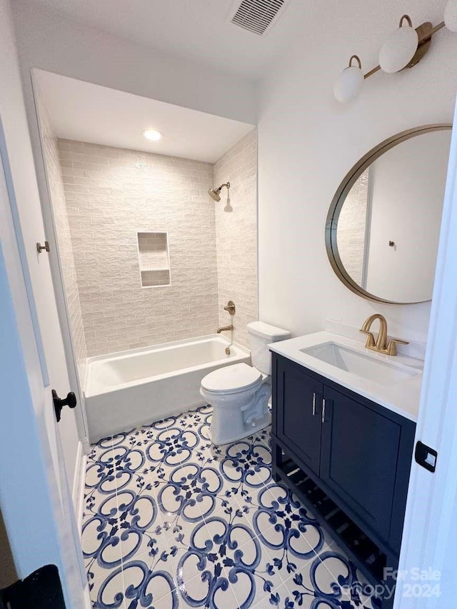 full bathroom with tiled shower / bath, vanity, toilet, and tile patterned floors