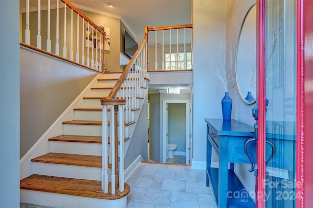 stairs featuring crown molding