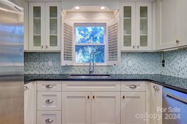 kitchen featuring backsplash, appliances with stainless steel finishes, sink, and white cabinets