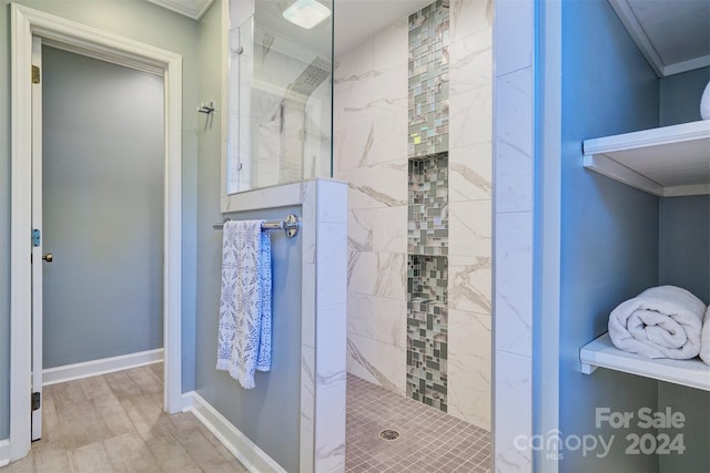 bathroom with tiled shower, ornamental molding, and hardwood / wood-style flooring