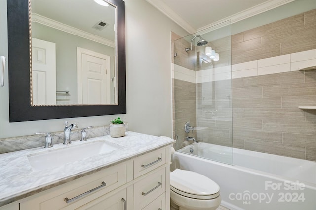 full bathroom featuring tiled shower / bath, vanity, crown molding, and toilet