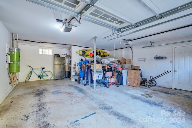 garage with a garage door opener, gas water heater, and stainless steel refrigerator