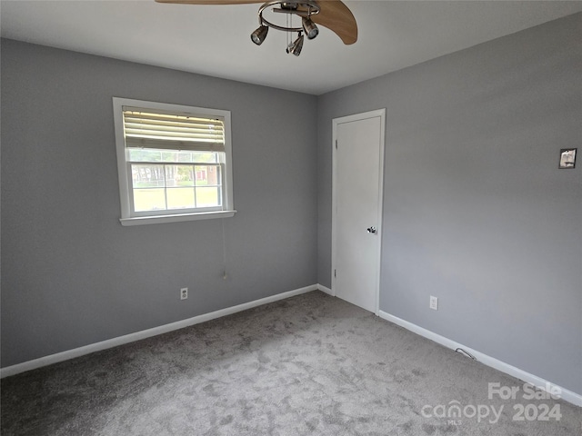 empty room featuring ceiling fan and carpet