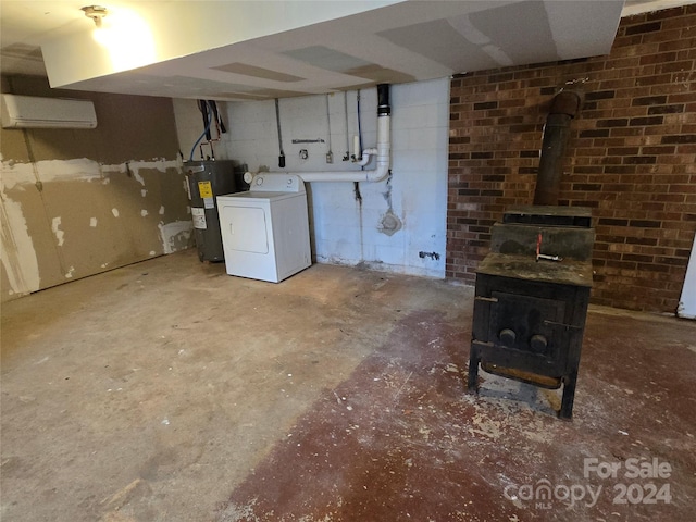 basement with a wood stove, washer / clothes dryer, and water heater