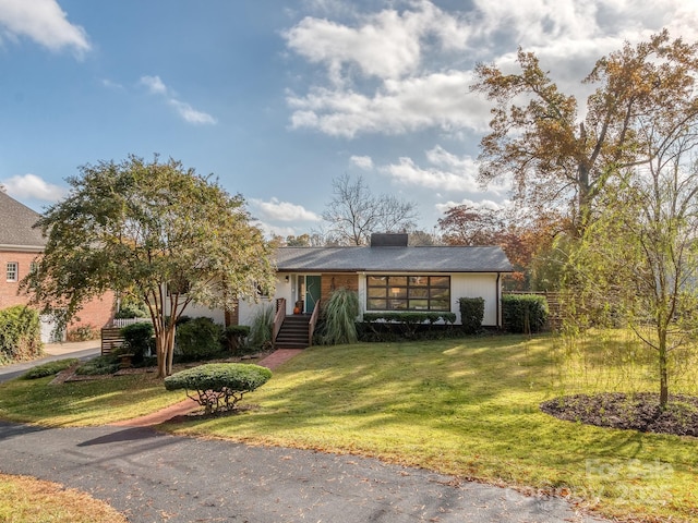 ranch-style home featuring a front lawn