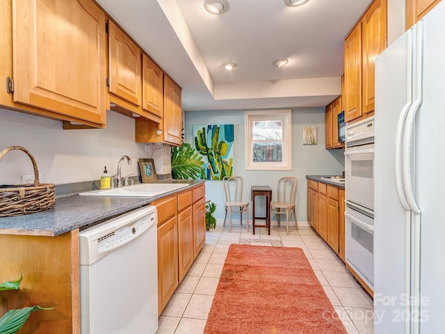 kitchen featuring white appliances, sink, and light tile patterned floors