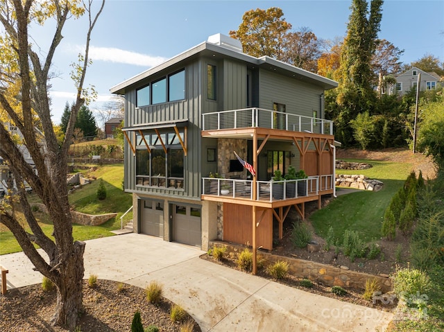 rear view of house with a yard, a balcony, and a garage