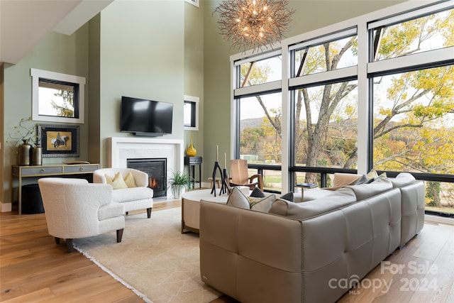 living room with a high ceiling, light hardwood / wood-style flooring, and a healthy amount of sunlight