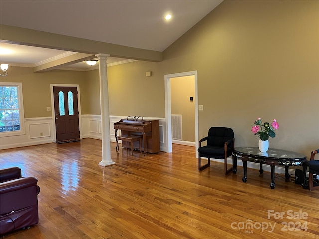 sitting room featuring decorative columns, crown molding, vaulted ceiling, hardwood / wood-style flooring, and a chandelier